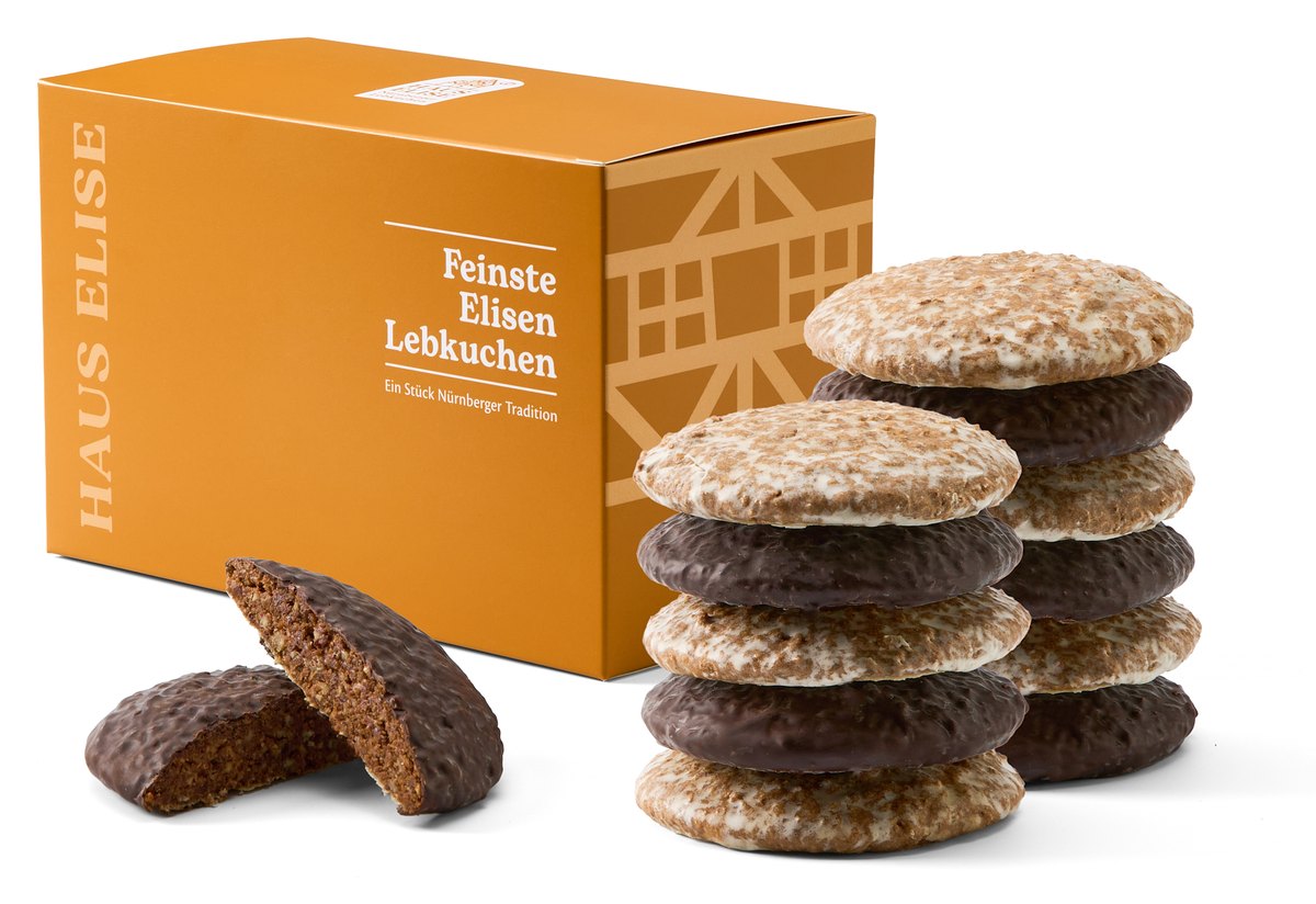 HAUS ELISE Elisen-Lebkuchen 12er Box mit Fachwerk-Motiv, daneben gestapelte Lebkuchen mit Zuckerglasur und Zartbitterschokolade