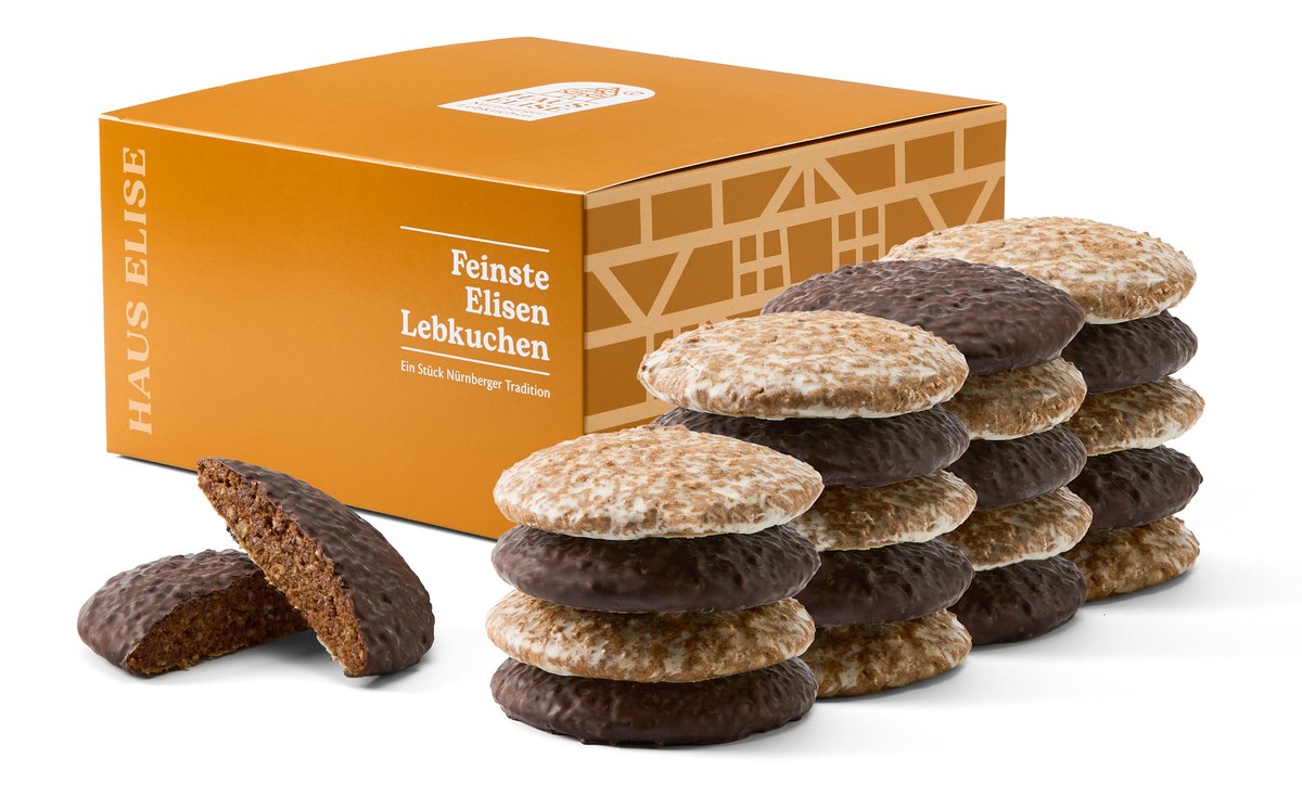 HAUS ELISE Elisen-Lebkuchen 20er Box mit Fachwerk-Motiv, daneben zwei Stapel gemischter Elisen-Lebkuchen